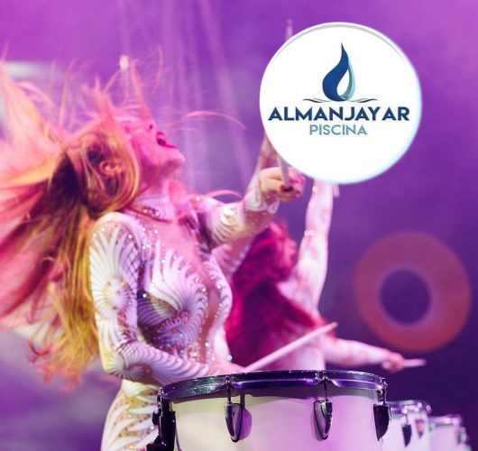 Group of female drummers in stage costumes in the circus arena in the light of spotlights and smoke